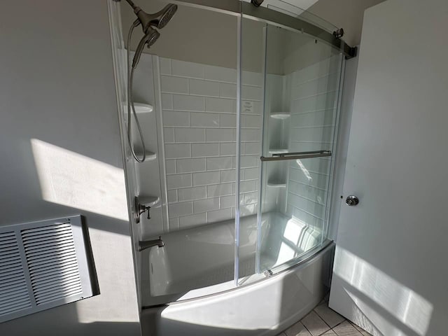 full bathroom featuring bath / shower combo with glass door, visible vents, and tile patterned floors