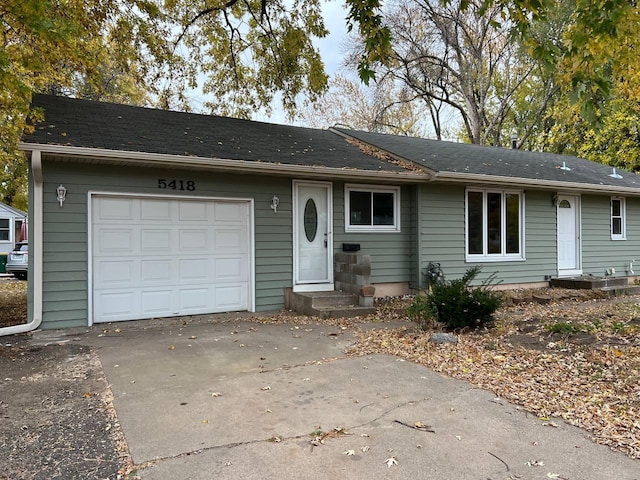 ranch-style house featuring a garage, entry steps, and concrete driveway