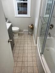 bathroom featuring toilet, tile patterned flooring, vanity, and baseboards