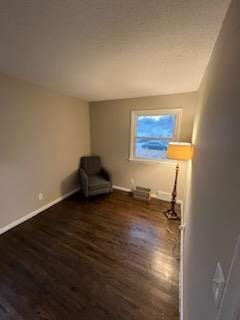 unfurnished room with baseboards and wood finished floors