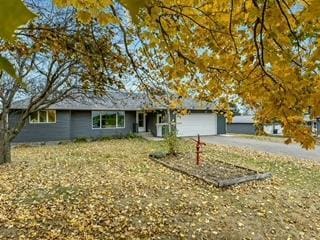 ranch-style home featuring a garage and driveway