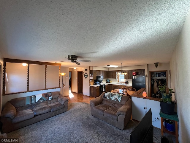 living room with hardwood / wood-style floors, a textured ceiling, and ceiling fan