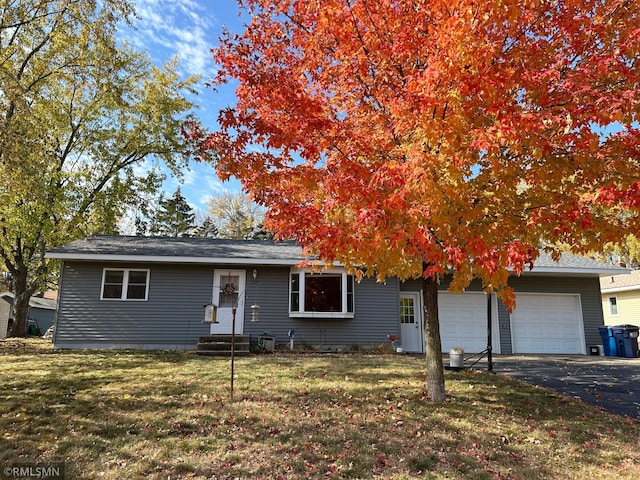 single story home featuring a garage and a front yard