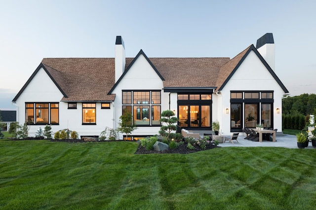 rear view of house with a yard and a patio