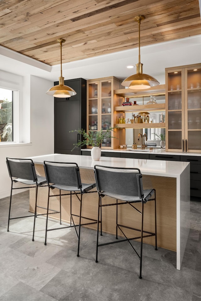 bar with decorative light fixtures, wood ceiling, and sink