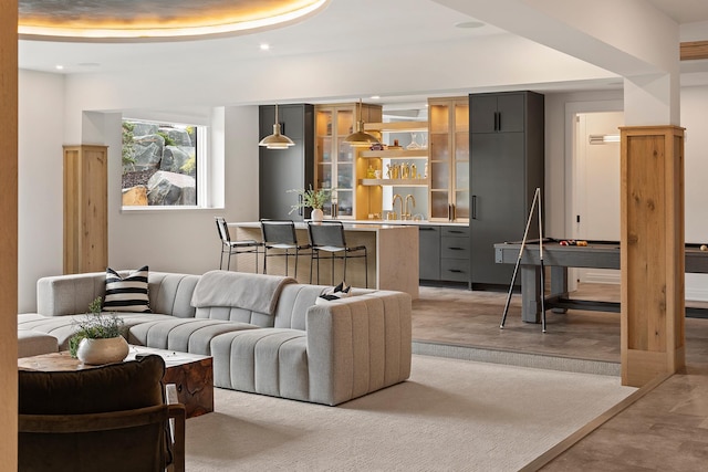 living room with a tray ceiling and sink