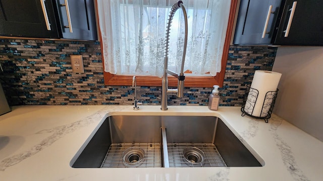 interior details featuring a sink, light countertops, and tasteful backsplash