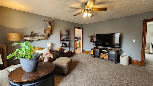 living area featuring baseboards, carpet flooring, a textured ceiling, and a ceiling fan