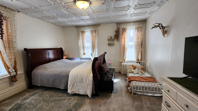 carpeted bedroom with radiator heating unit and baseboards