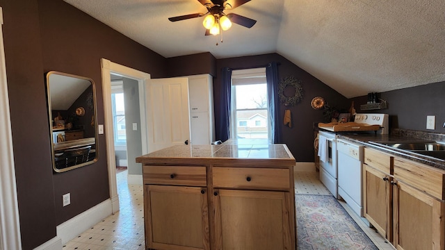 kitchen featuring baseboards, lofted ceiling, white dishwasher, and a textured ceiling