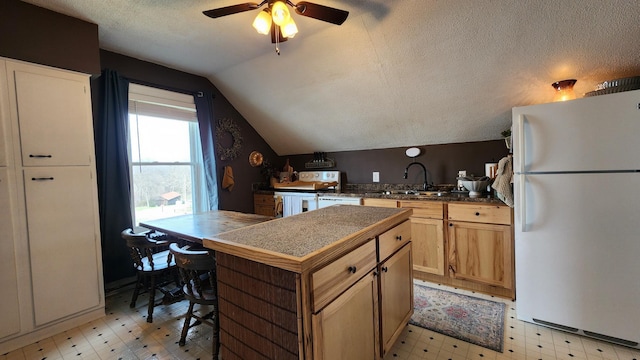 kitchen featuring white appliances, light floors, vaulted ceiling, a kitchen island, and a sink