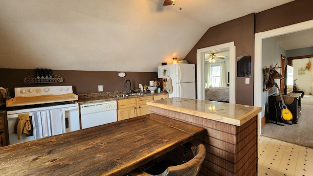 kitchen featuring vaulted ceiling, white appliances, ceiling fan, tile countertops, and a sink