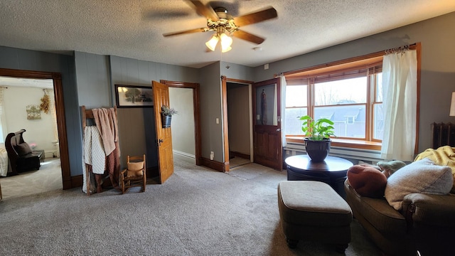 living area featuring light colored carpet, ceiling fan, baseboards, and a textured ceiling