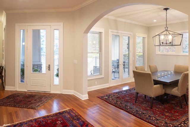 dining area featuring crown molding, hardwood / wood-style flooring, french doors, and a chandelier