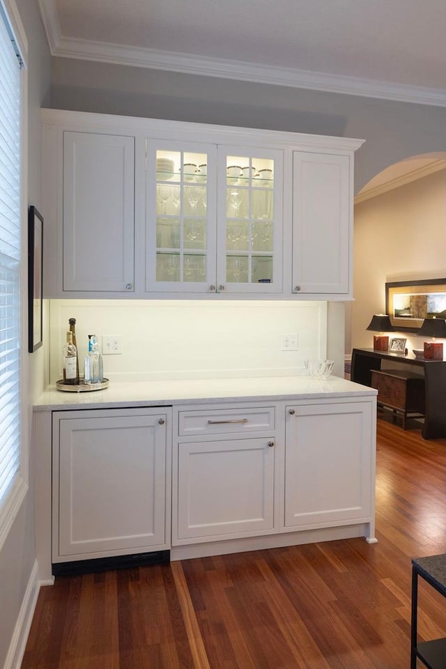 bar featuring white cabinetry, dark wood-type flooring, and ornamental molding