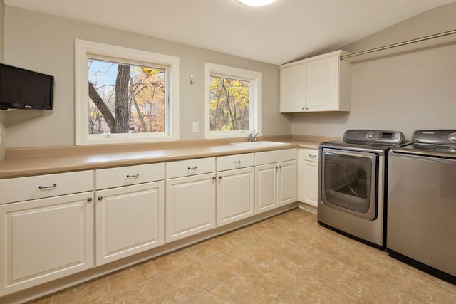 washroom with cabinets, sink, and washing machine and dryer