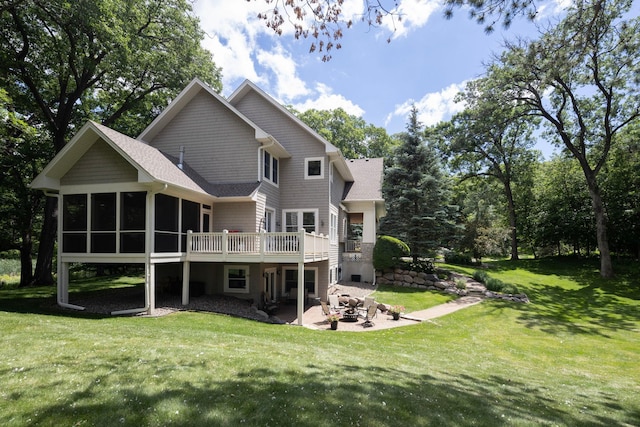 rear view of house featuring a wooden deck, a yard, a patio area, and a sunroom