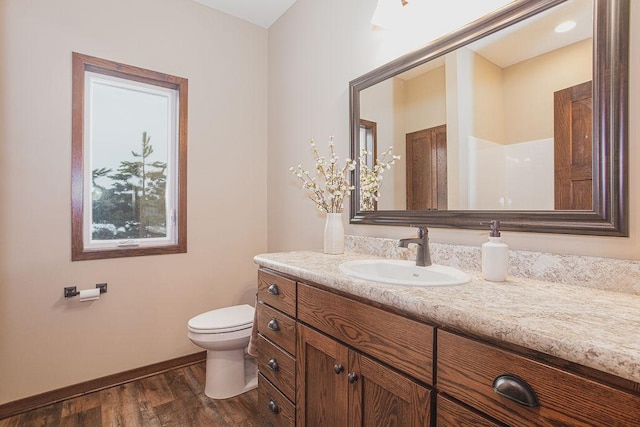 bathroom with hardwood / wood-style flooring, vanity, and toilet