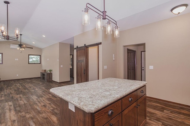 kitchen with a barn door, a kitchen island, pendant lighting, and vaulted ceiling