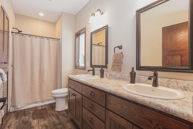 bathroom featuring hardwood / wood-style floors, vanity, toilet, and walk in shower