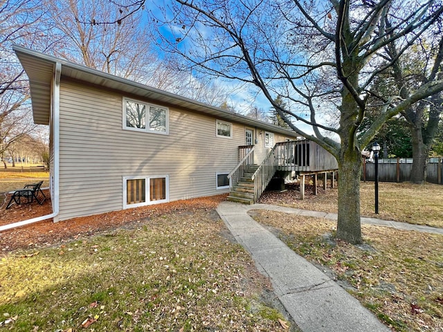 rear view of property with a deck and a lawn