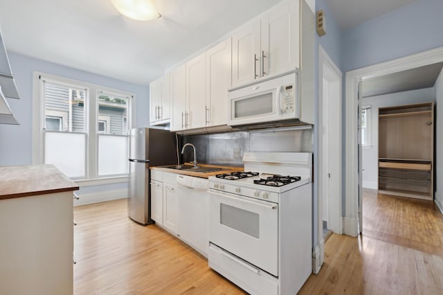 kitchen with tasteful backsplash, white cabinetry, white appliances, and light hardwood / wood-style flooring