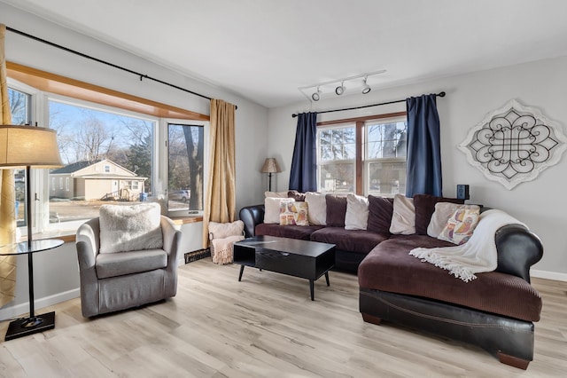 living room featuring rail lighting, baseboards, and wood finished floors