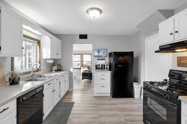 kitchen featuring black appliances, light wood-style floors, light countertops, and under cabinet range hood