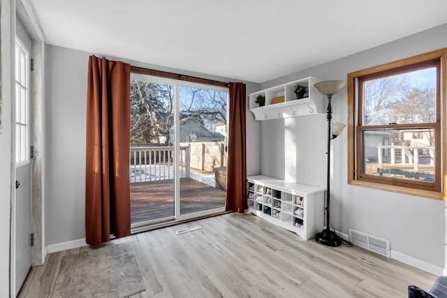 mudroom with a healthy amount of sunlight, visible vents, light wood-style flooring, and baseboards