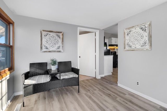 living area featuring light wood-style flooring and baseboards