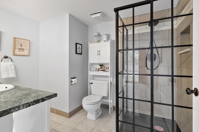 bathroom featuring visible vents, toilet, a sink, a walk in shower, and baseboards