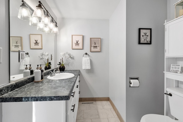 bathroom featuring marble finish floor, vanity, toilet, and baseboards