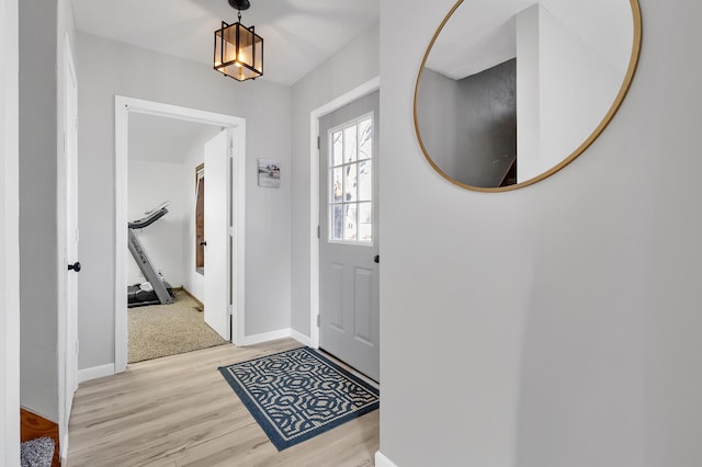 foyer with light wood-type flooring and baseboards