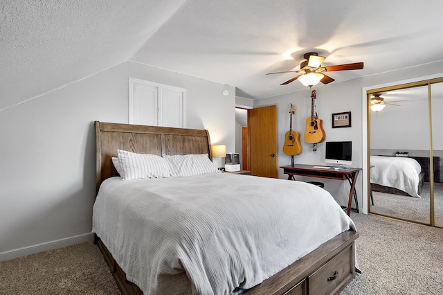 carpeted bedroom featuring lofted ceiling, a closet, a ceiling fan, a textured ceiling, and baseboards