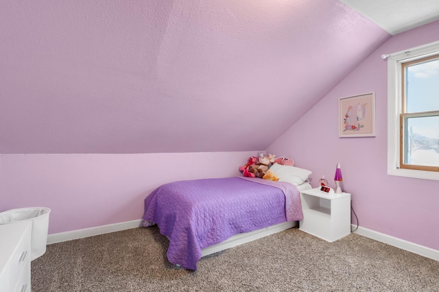 bedroom with lofted ceiling, carpet, baseboards, and a textured ceiling