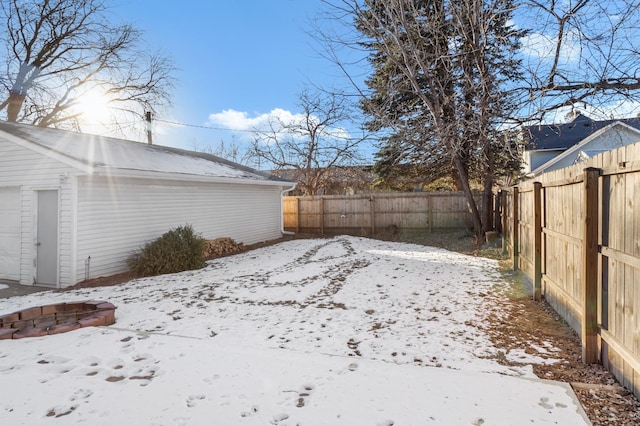 snowy yard featuring a fenced backyard