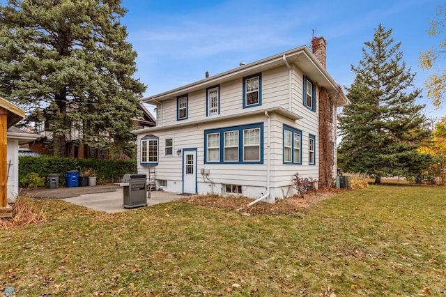 rear view of property featuring a yard, a patio, and central AC unit