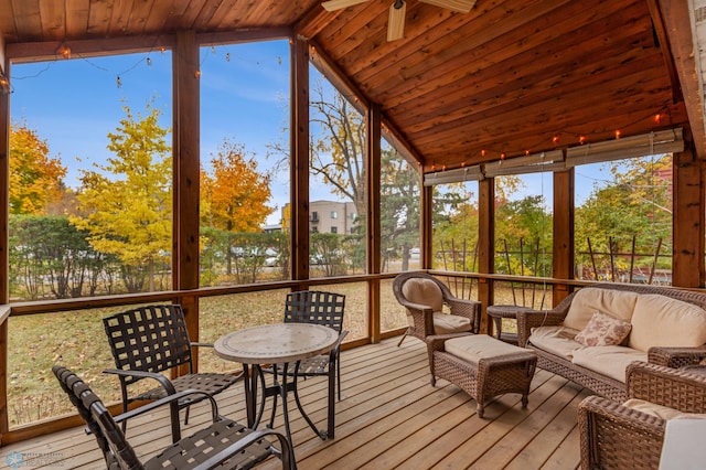 sunroom / solarium featuring vaulted ceiling with beams, ceiling fan, a healthy amount of sunlight, and wood ceiling