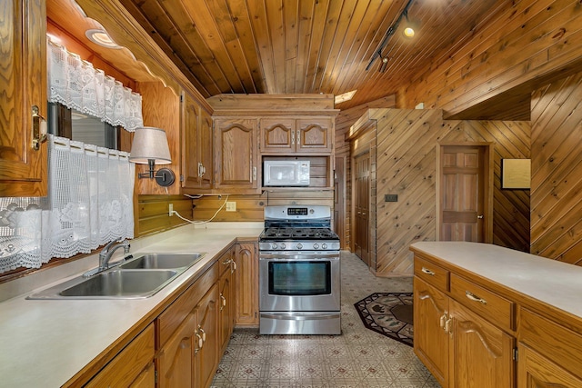 kitchen with white microwave, light countertops, wooden ceiling, stainless steel gas stove, and a sink