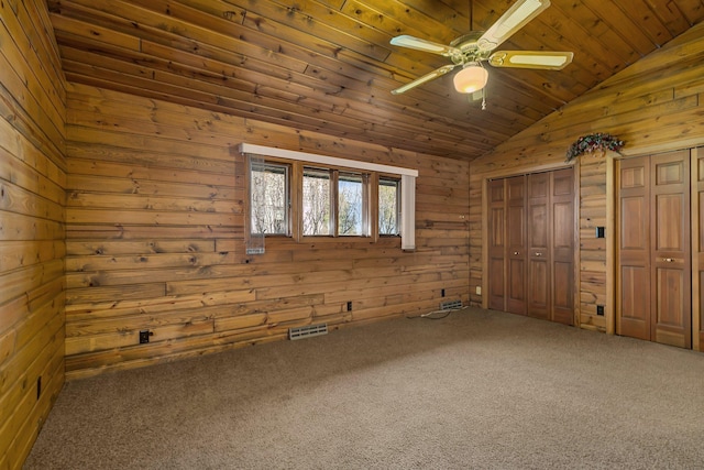 unfurnished bedroom with visible vents, two closets, carpet floors, vaulted ceiling, and wooden ceiling