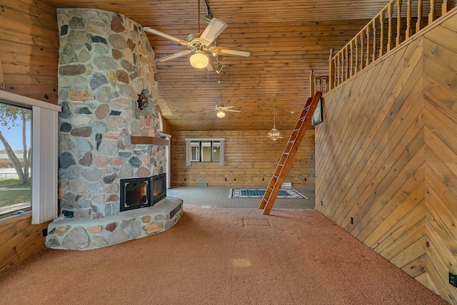 unfurnished living room with wooden walls, a fireplace, and carpet