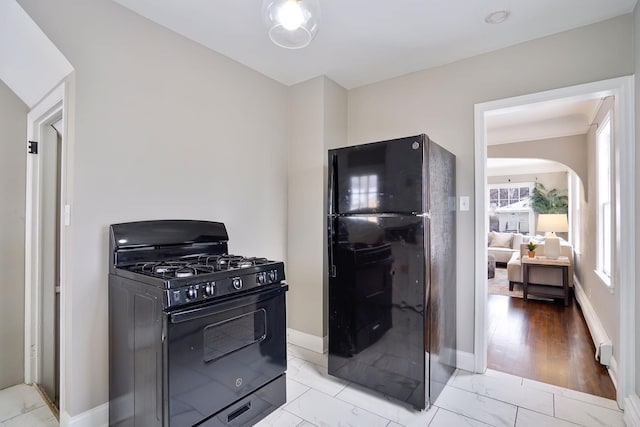 kitchen with light hardwood / wood-style flooring and black appliances