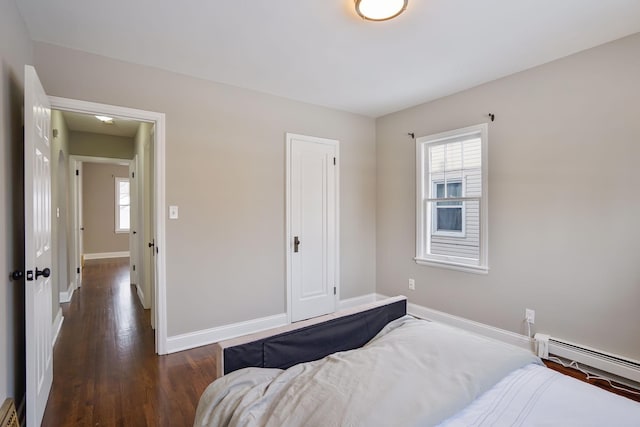 bedroom with dark hardwood / wood-style flooring and baseboard heating