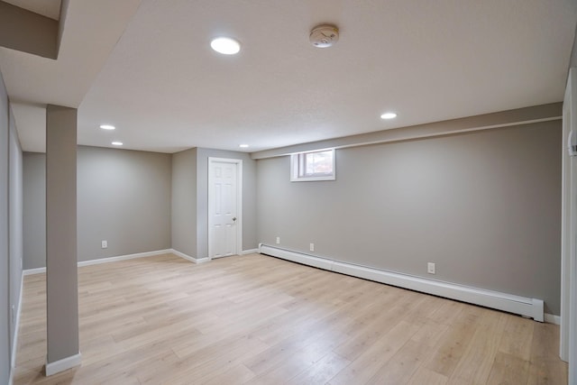 basement with a baseboard radiator and light hardwood / wood-style floors