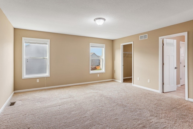 carpeted empty room featuring a textured ceiling