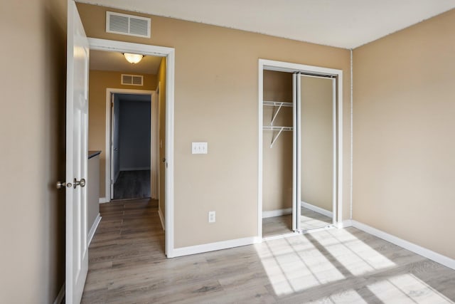 unfurnished bedroom with light hardwood / wood-style floors and a closet