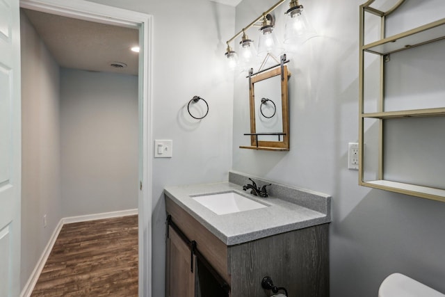 bathroom featuring vanity, hardwood / wood-style flooring, and toilet