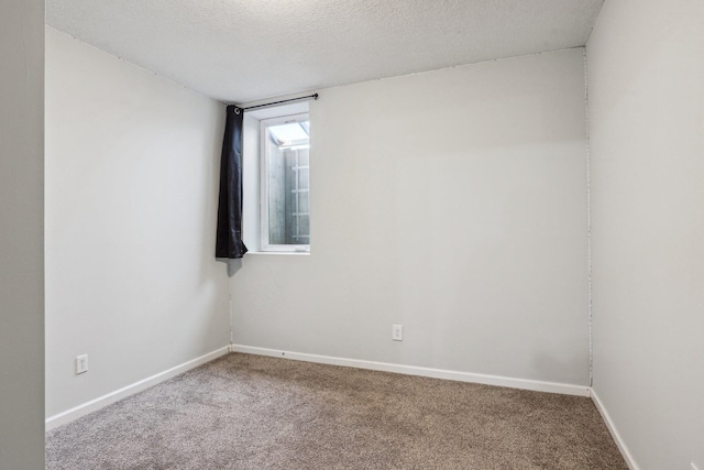 carpeted empty room featuring a textured ceiling