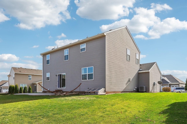 rear view of property featuring a lawn and cooling unit