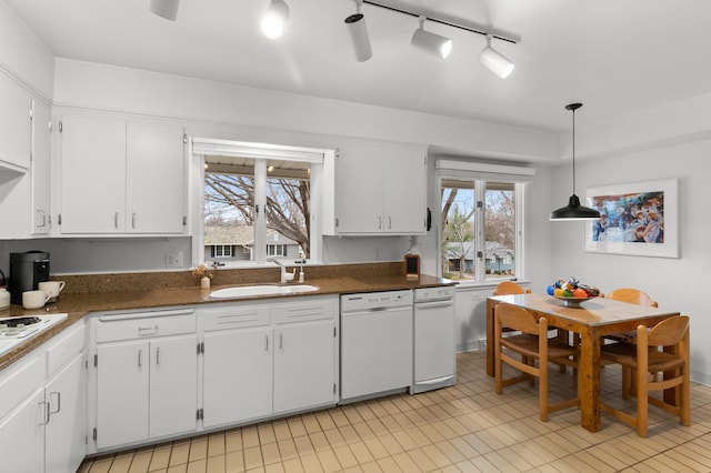 kitchen featuring track lighting, white appliances, white cabinetry, a sink, and light tile patterned floors